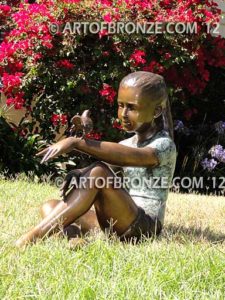 Garden Surprise bronze sculpture of girl sitting with crossed legs and bird on her hand