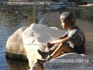 Fish n Hole bronze sculpture of young boy sitting and fishing