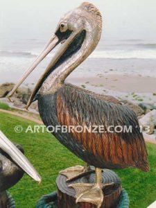 Taking a Break bronze statue of playful pelicans on bronze pilings