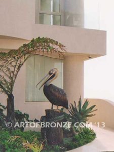 Taking a Break bronze statue of playful pelicans on bronze pilings