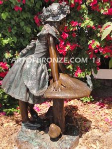 Wonderland bronze sculpture of giant mushroom and standing girl with frog