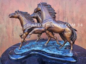 Wild & Free sculpture of charging horses and foal attached to a marble base