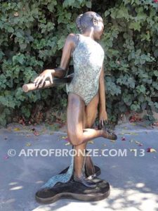 Rehearsal bronze sculpture featuring young ballerina practicing on rail