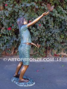 Faith bronze sculpture of young standing girl with doves in her hands