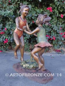 Dance Around bronze sculpture of two girls holding hands and dancing