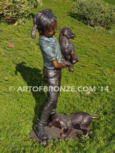 Play with Me Too bronze sculpture of girl holding dog with other dog chewing on her shoelace