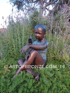 Garden Surprise bronze sculpture of girl sitting with crossed legs and bird on her hand