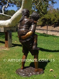 Piggyback bronze statue of boy carrying young girl on his back