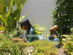 Best in Her Class front view bronze statue of girl lying down reading book