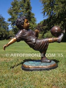 Lil Scorer sculpture of boy playing AYSO soccer bicycle kicking ball into goal