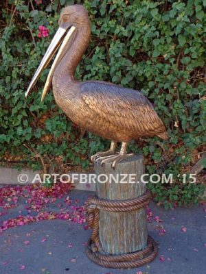 Pelican Perch bronze statue of playful pelican on bronze piling