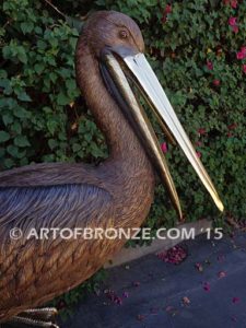 Pelican Perch bronze statue of playful pelican on bronze piling