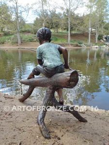 Fish n Day bronze sculpture of young boy sitting on log fishing