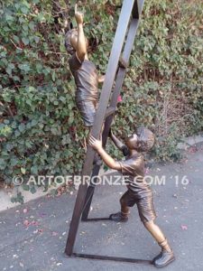 Team Work bronze sculpture of two boys climbing ladder working on house