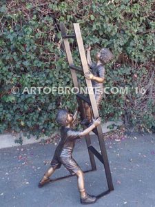 Team Work bronze sculpture of two boys climbing ladder working on house