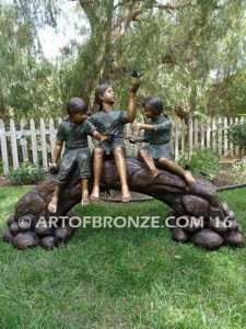 Butterfly Enchantment bronze statue of three children sitting on log playing with butterflies