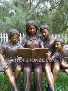 Making a Difference bronze sculpture of four children sitting on bench reading a book