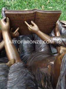 Making a Difference bronze sculpture of four children sitting on bench reading a book