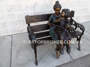 Mom Knows Best Bronze sculpture of little girl sitting on moms lap being read a book