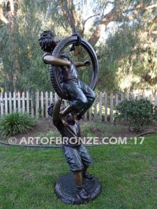 tire swing sculpture two boys playing on swing