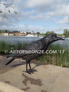 Raven bronze sculpture of ravens playing bench at lake