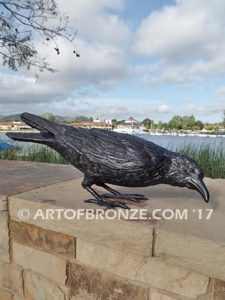 Raven bronze sculpture of ravens playing bench at lake