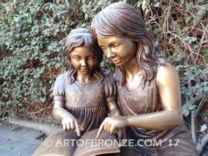 Together Forever bronze sculpture of older girl tutoring younger girl with book