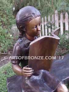 Little learner sculpture of sitting girl reading book on bench