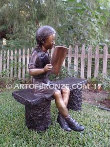 Little learner sculpture of sitting girl reading book on bench