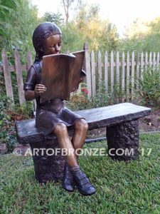 Little learner sculpture of sitting girl reading book on bench