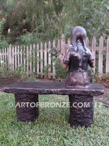 Little learner sculpture of sitting girl reading book on bench