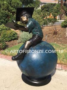 Global Scholar bronze sculpture of boy sitting on globe wearing graduation cap and reading book