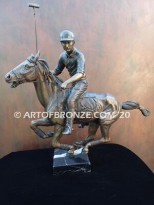 Downfield sculpture of polo player riding his leaping polo pony attached to a marble base