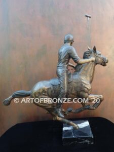 Downfield sculpture of polo player riding his leaping polo pony attached to a marble base