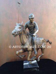 Downfield sculpture of polo player riding his leaping polo pony attached to a marble base