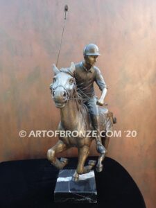 Downfield sculpture of polo player riding his leaping polo pony attached to a marble base