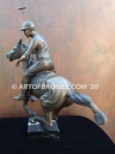 Downfield sculpture of polo player riding his leaping polo pony attached to a marble base