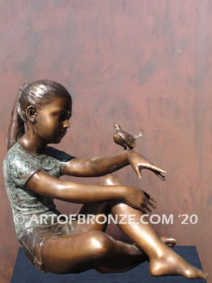 Garden Help bronze sculpture of girl sitting with crossed legs and bird on her hand