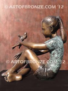 Garden Help bronze sculpture of girl sitting with crossed legs and bird on her hand