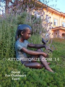 Garden Help bronze sculpture of girl sitting with crossed legs and bird on her hand