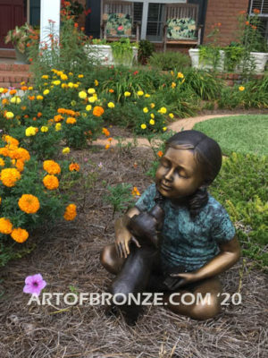 Give me Attention bronze statue girl sitting down playing with puppy dog on her lap