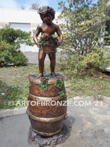 Harvest Time bronze sculpture of cherub boy standing on wine barrel with grapes on display at Tunnel Creek Vineyards & Winery