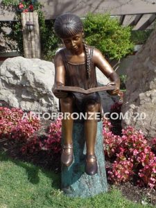 Study Time bronze sculpture of young reader girl sitting on bronze stump