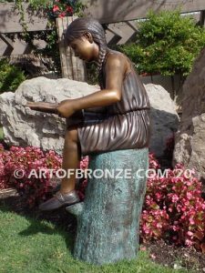 Study Time bronze sculpture of young reader girl sitting on bronze stump