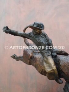 All on the Line sculpture of cowboy riding jumping bull attached to a marble base