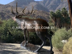 Heroic bronze bull elk standing on rocky base design with head raised in bugling position