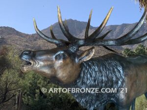 Heroic bronze bull elk standing on rocky base design with head raised in bugling position