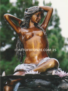 Mirage bronze sculpture of nude woman resting on rocks with lily pads