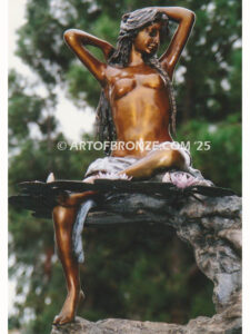 Mirage bronze sculpture of nude woman resting on rocks with lily pads