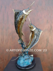 Parlay bronze sculpture of two marlins leaping upward above ocean waves on marble base